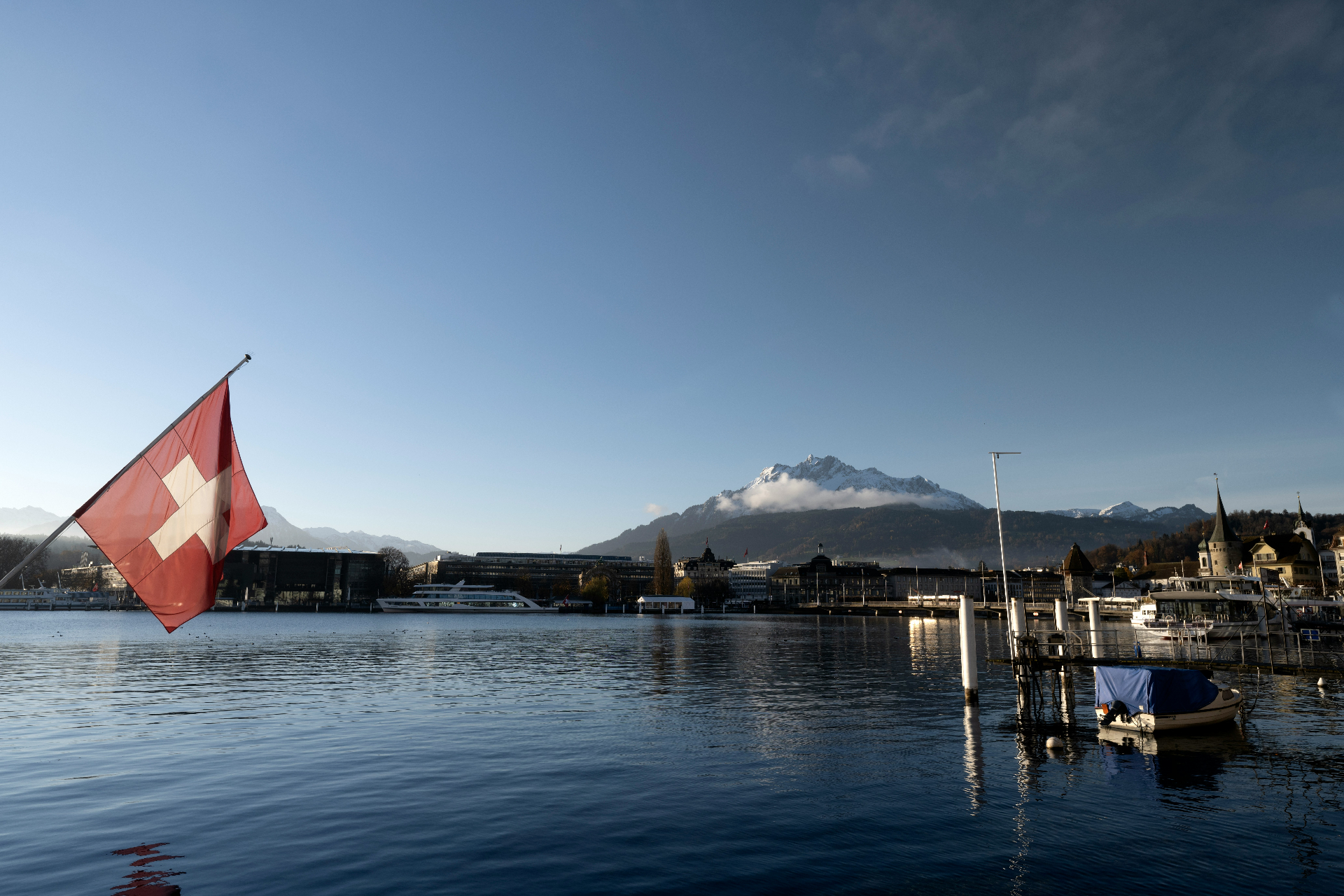 Lake Lucerne at dusk with Swiss flag and alpine mountains